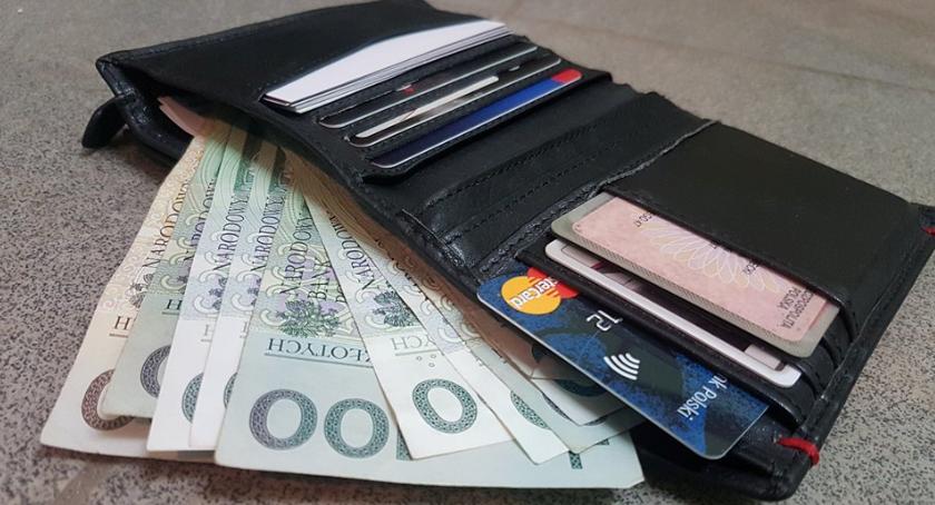 Zdjęcie poglądowe przedstawia gotówkę, dokumenty i karty bankowe.